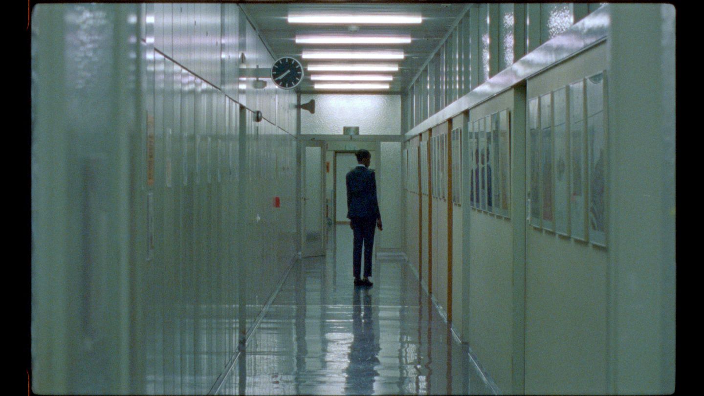Image from Night Shift of a security guard played by Kayije Kagame in a nondescript hallway.